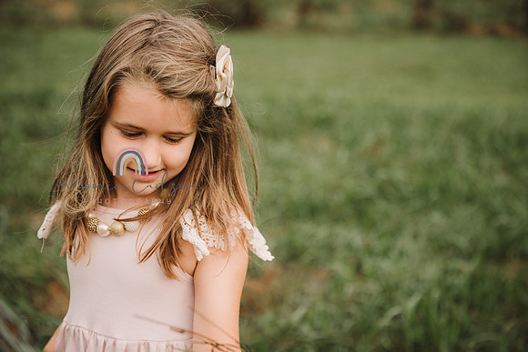 little girl looks whistfully on a green field