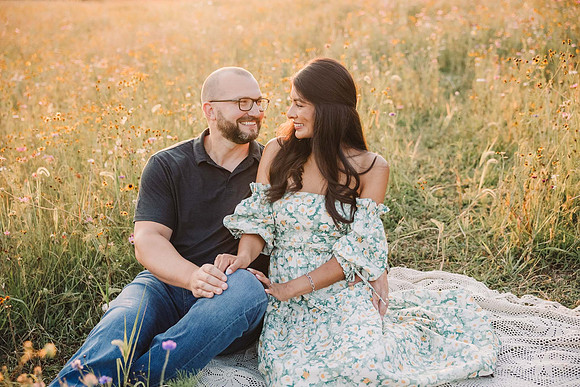 couple looking at each other on a wildflower field