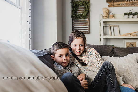 sister and brother sitting on the couch of their home living room
