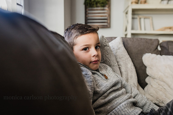 serious portrait of a boy sitting on a couch