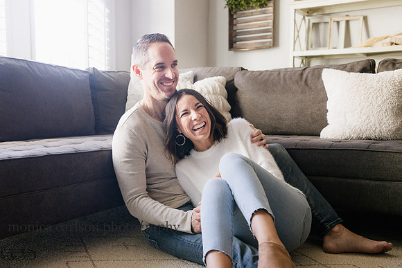 husband and his wife snuggle on the floor of their living room