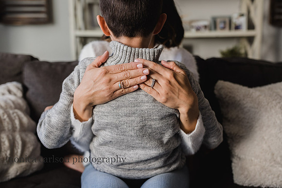 mothers hands resting on her sons back