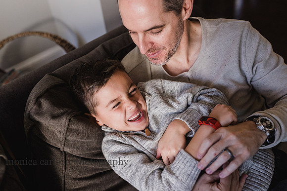 dad tickling his son by monica carlson
