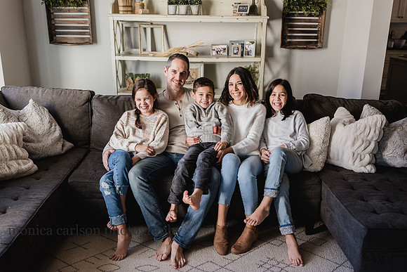 family of five pose for a photo in their living room
