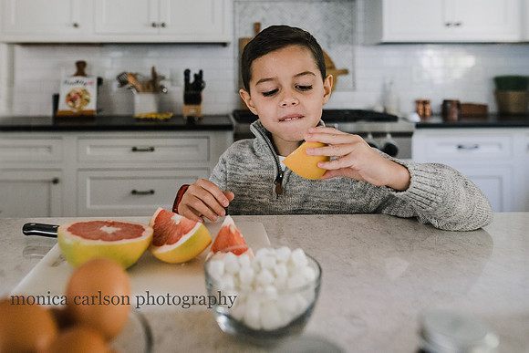 little boy eating a orange