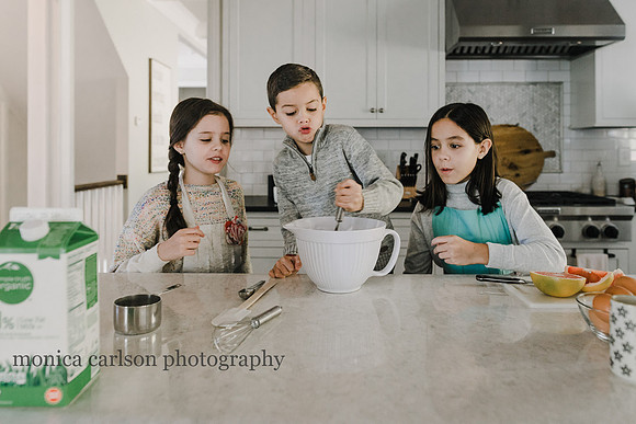 three siblings stirring batter in their kitchen
