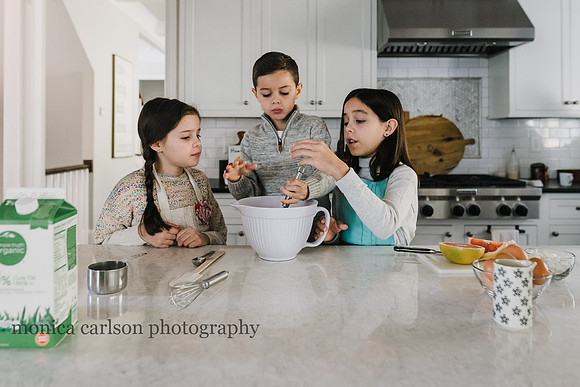 sisters helping their brother stir pancake batter