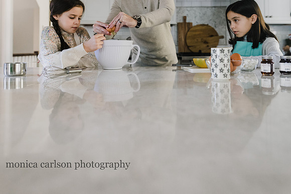 girls preparing pancakes with their father