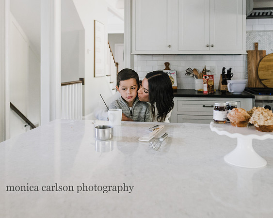 mother kissing her son in the kitchen