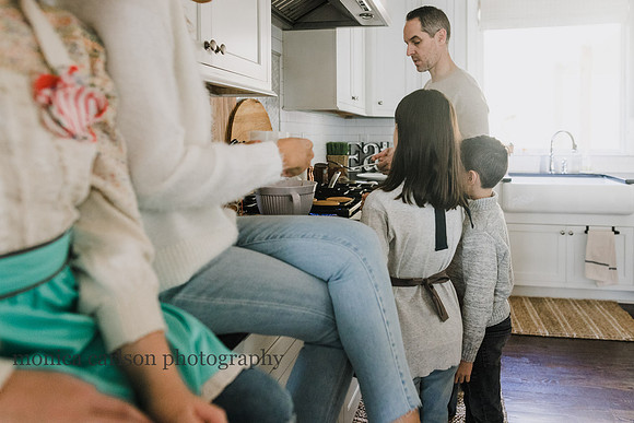 Family watching father cook breakfast in the kitchen