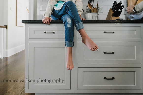 mothers feet while she sits on a kitchen counter