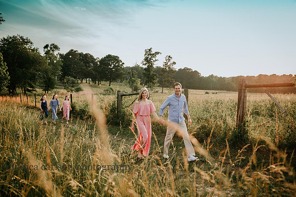 parents walking with daughter behind them on a field