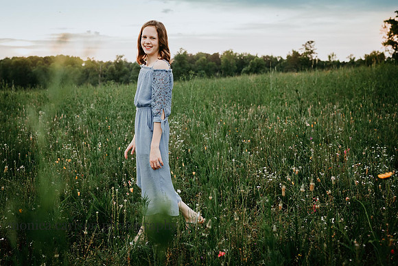 tween girl walking through a field during a family photo session