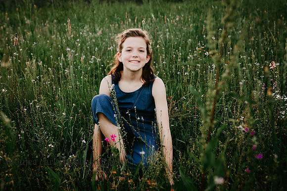 little girl sitting in a wildflower field at Prospect farms