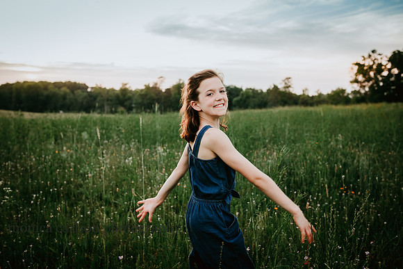 Young girls skipping through a flower field during a lifestyle photo session with Monica carlson