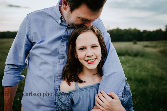 dad kissing his tween daughter on the head during a family photo session at Prospect farms