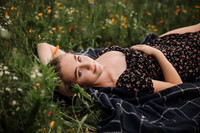high school senior lying in a flower field