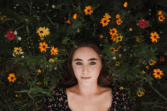 looking down at a girl surrounded by flowers