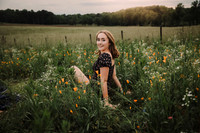 Teen sitting in a field of flowers at sunset