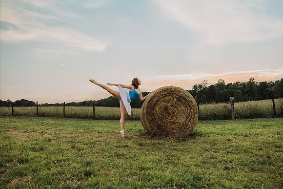 ballerina with a haybale at sunset