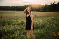 high school senior flipping her hair on a wildflower field
