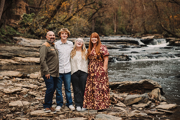 family stands on rocks near vickery creek