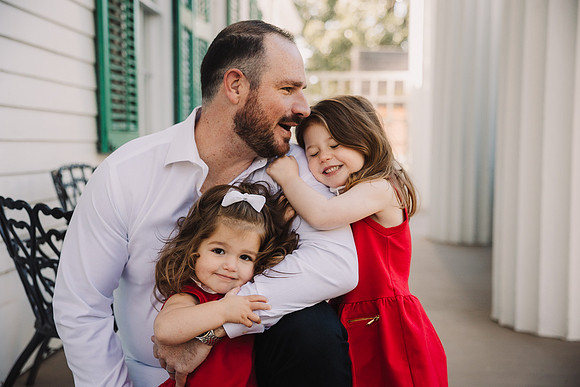 Toddler girls love on their father