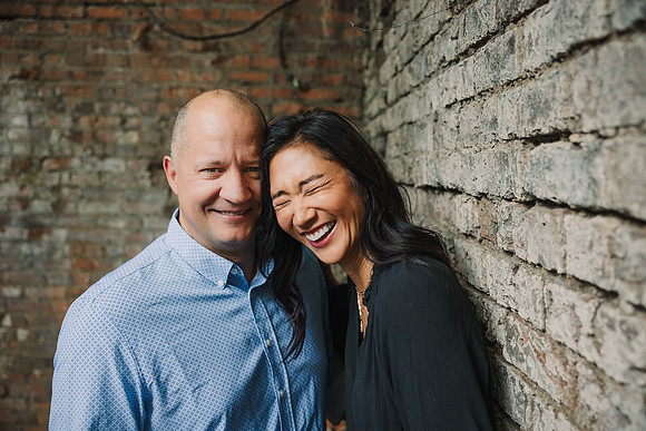 Husband and wife laugh together while standing in ruins at Roswell Mill