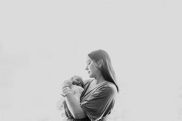 Backlit image of a mother holding her newborn son