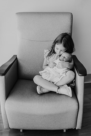 Toddler holds her new brother