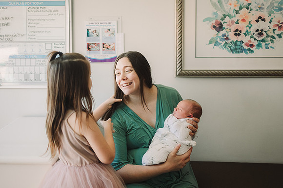 New mom smiles at older daughter