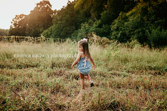 little girl walking across a field during a family photo session