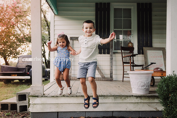 brother and sister jumping from a wooden patio