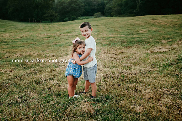 boy and girl hugging on field by monica carlson