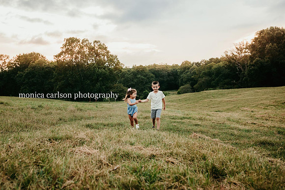 siblings running on a open field by monica carlson photography