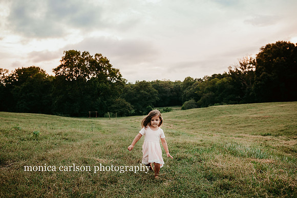 three year old girl running through a field