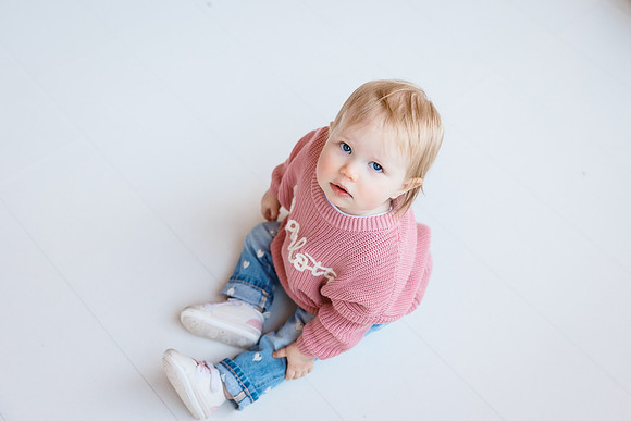 portrait of a girl from above sitting on a white floor