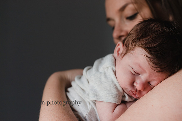 squishy newborn baby sleeping on his mothers shoulder by monica carlson