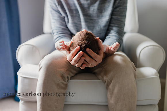 Father cradling his newborn sons head in his hands