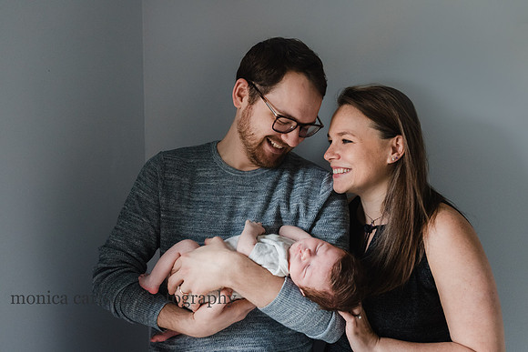 proud new parents holding their baby at home in Atlanta