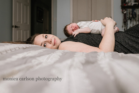 glowing mother laying with her new son on her chest taken by monica carlson