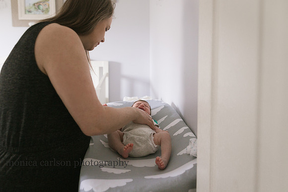 woman changing her crying sons diapers in their atlanta home