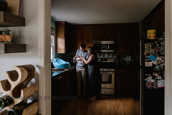 husband and wife bathing their newborn in their kitchen at home in Atlanta
