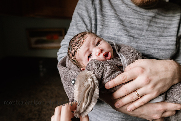 sweet baby being dried off after a bath by his parents