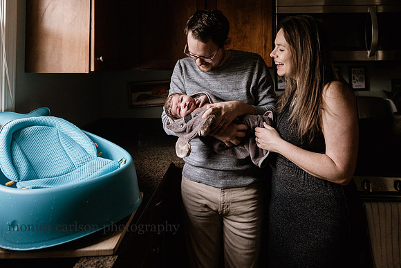 mother and father enjoying their new baby's first bath
