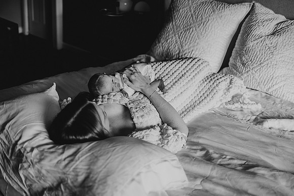 mother lays on her back while baby lays on her chest