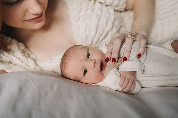 close up of a mom cuddling her new baby