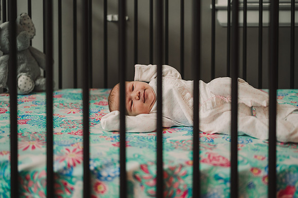 newborn stretching in bed
