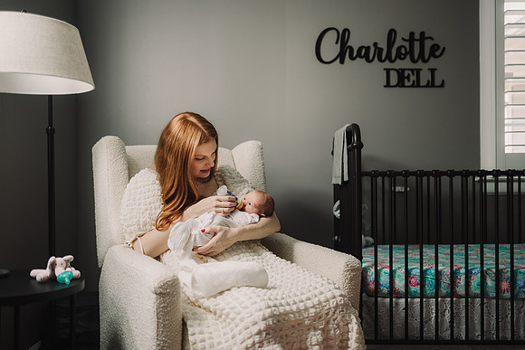 Mother feeding new baby during photo session by monica carlson