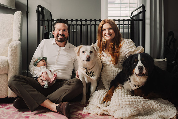 family of three and their two dogs pose for a portrait